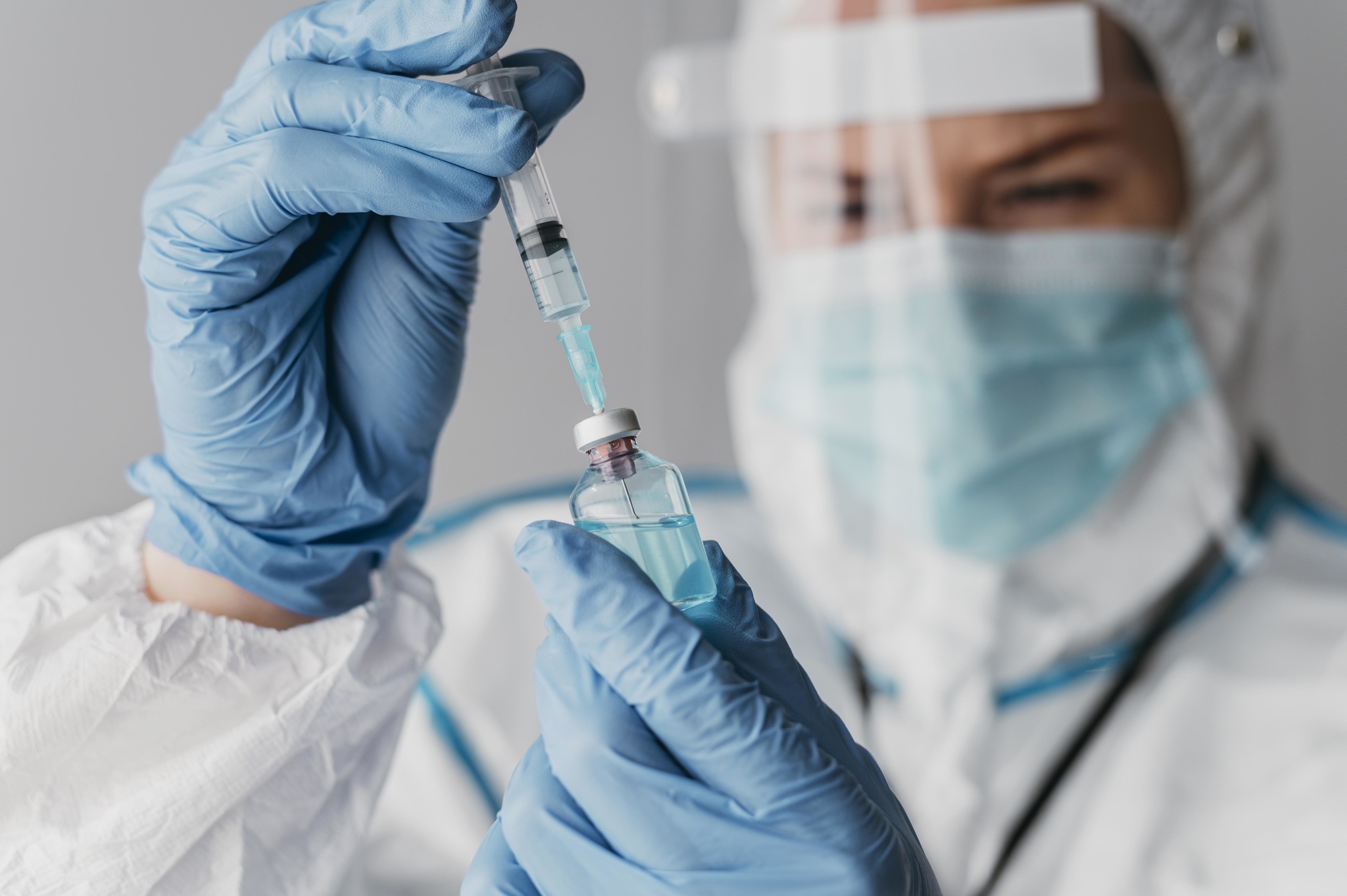 doctor-holding-preparing-vaccine-while-wearing-protective-equipment.jpg