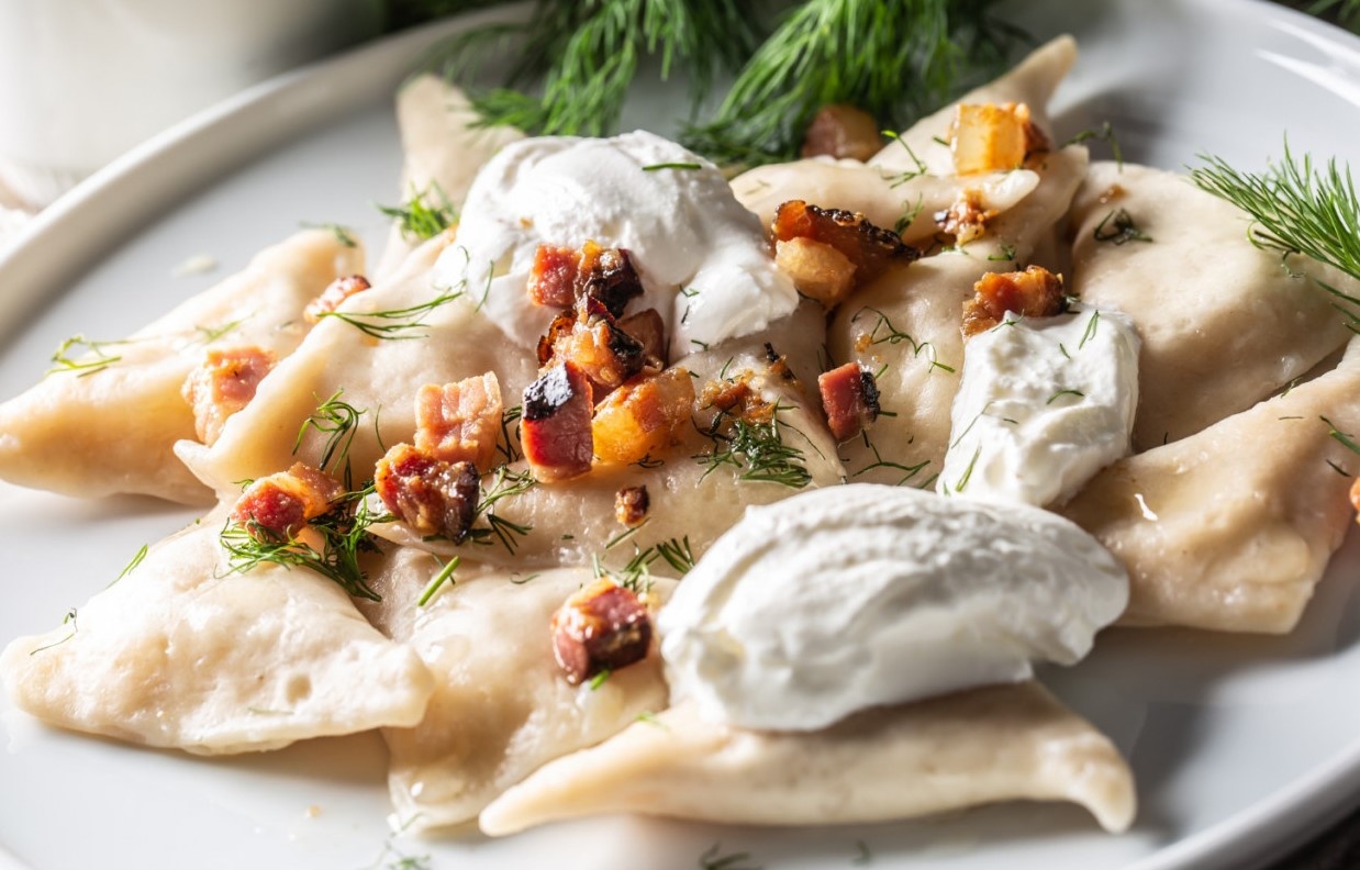 filled-pirohy-dish-served-with-fried-bacon-fresh-dill-and-sour-cream.jpg